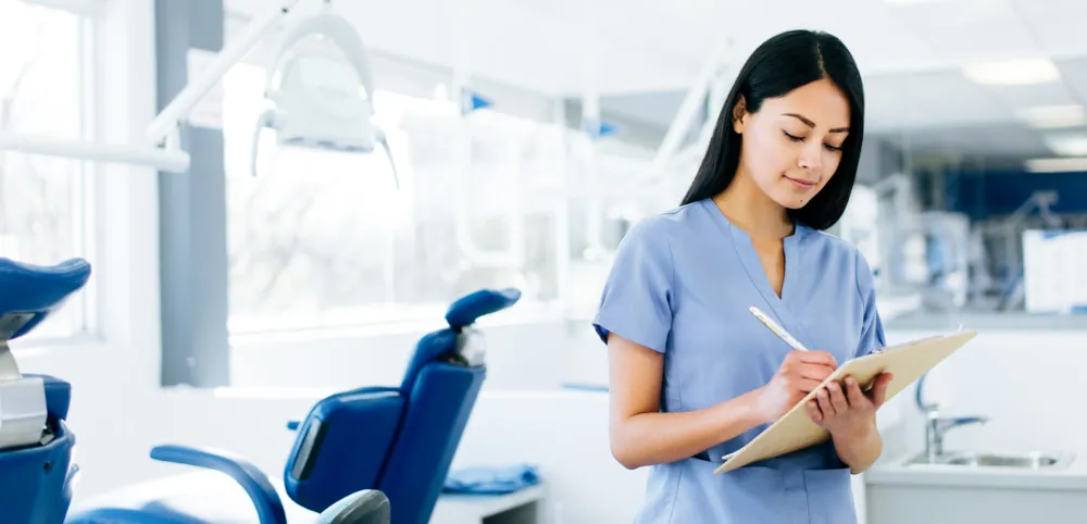 Auxiliar de clínica registrando datos de paciente en entorno hospitalario (uso de ActualPACS Centers)